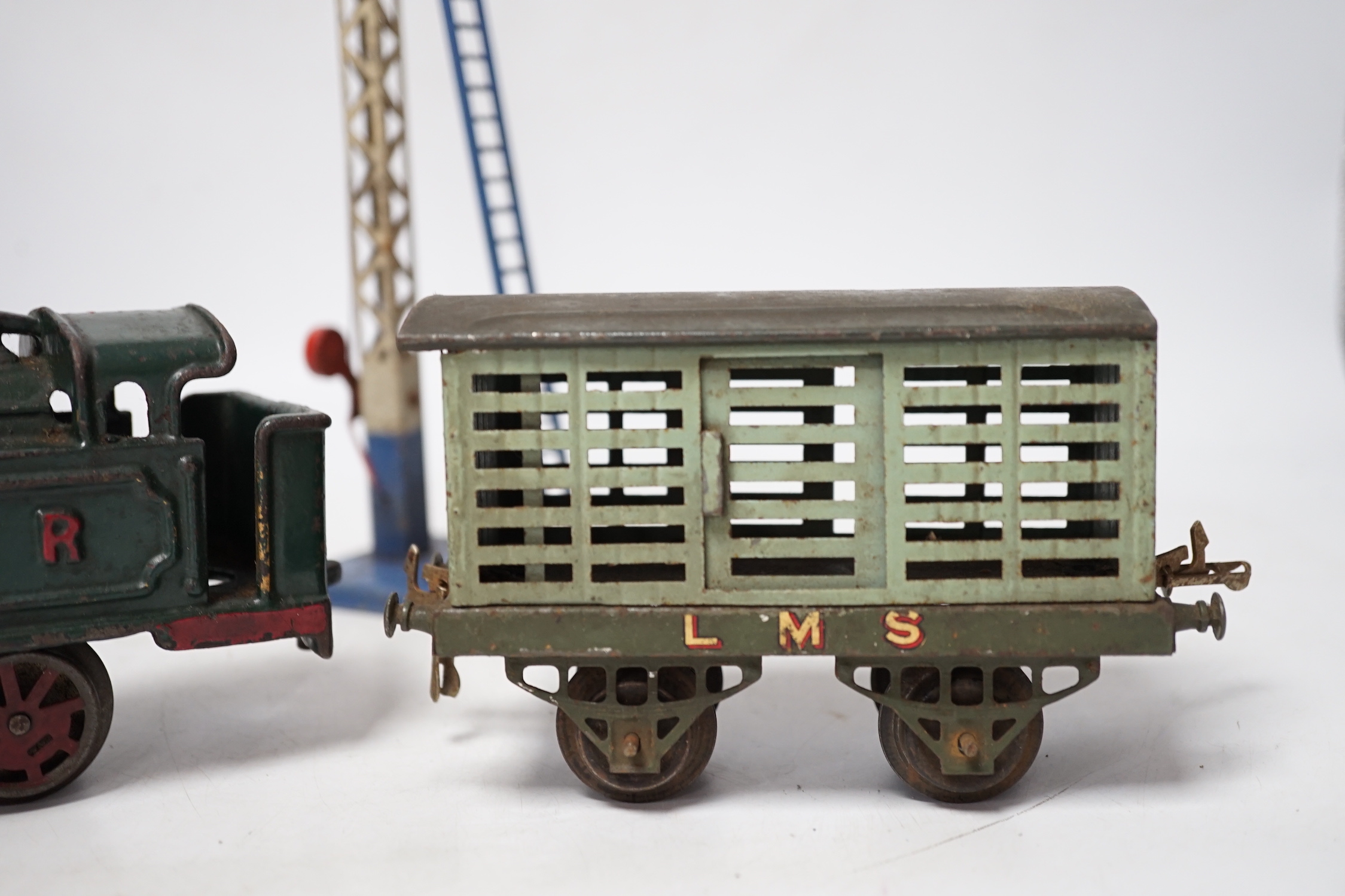 A collection of O gauge clockwork tinplate model railway, including a cast iron clockwork, GNR, 0-4-0T locomotive, six Hornby freight wagons, a small quantity of curved Bassett Lowke track sections and a few other items